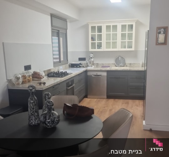מטבח מודרני עם שולחן עגול וכיסאות לבנים
